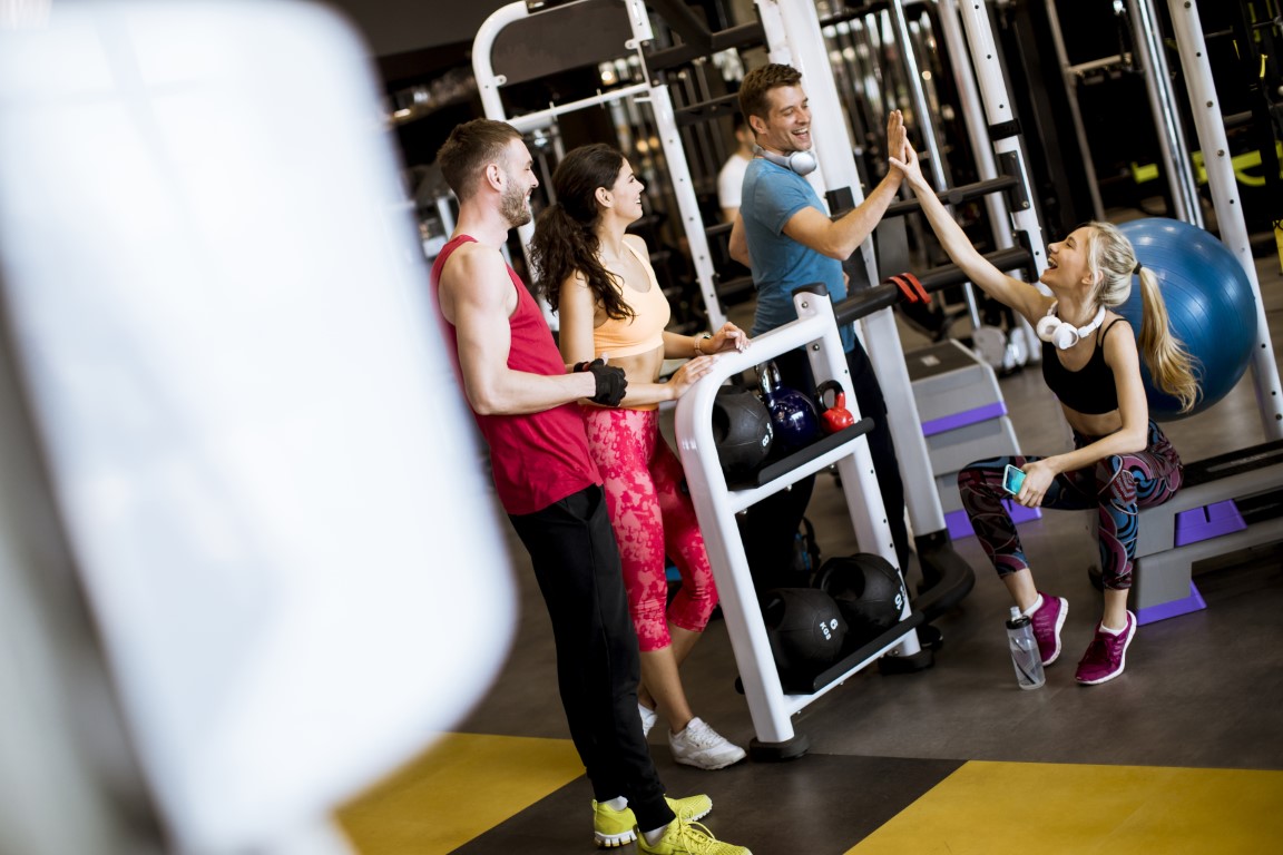 Group of young people in sportswear talking in a gym after a workout